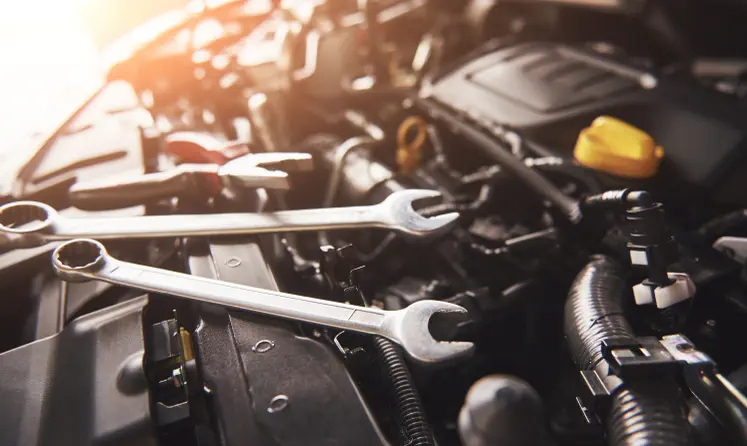 Herramientas de mecánico sobre el motor de un carro durante una revisión
